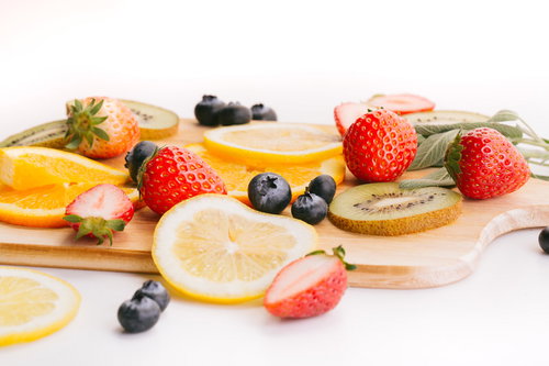 木製のまな板に並ぶカットフルーツのデザート