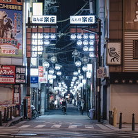 難波の繁華街を照らすネオン看板が並ぶ路地裏の写真