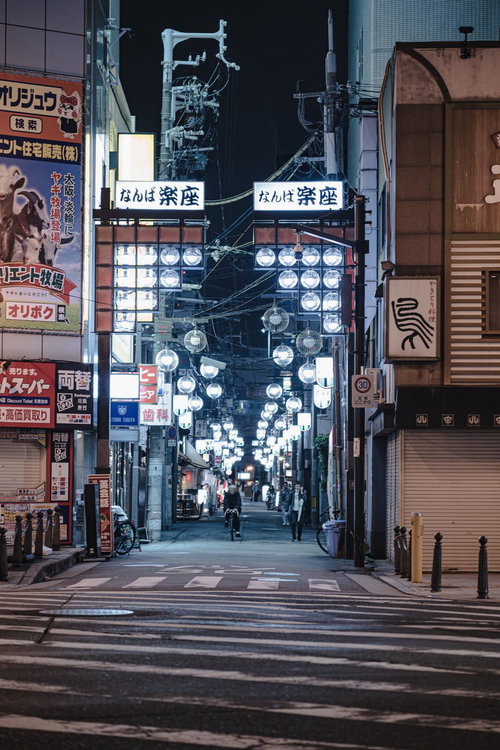 難波の繁華街を照らすネオン看板が並ぶ路地裏