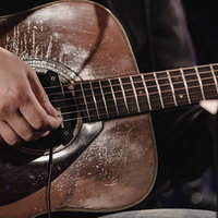 アコースティックギターを演奏する手元の弾き方の写真