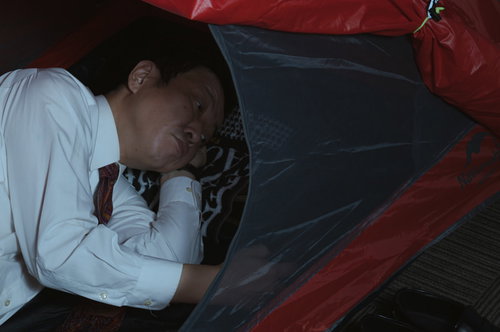 車内で仮眠をとる疲弊した営業マンの休息風景