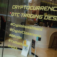 暗号資産取引デスクの店舗看板とビットコイン投資取引フロアの写真