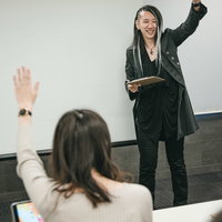 セミナーで参加者に挙手してもらう男性講師の写真