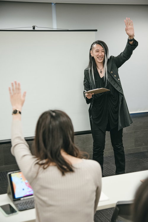 セミナーで参加者に挙手してもらう男性講師