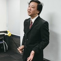 今から話すところはテストに出ます、とスーツ姿で講義する男性講師の写真