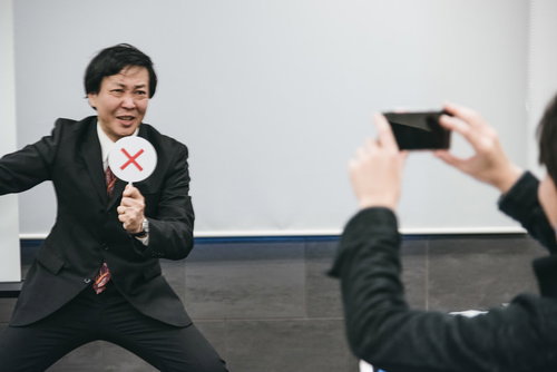 不正解ですぶっぶーと指摘するスーツ姿の男性