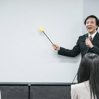 ホワイトボードを見ながら登壇するセミナー講師の講義風景の写真