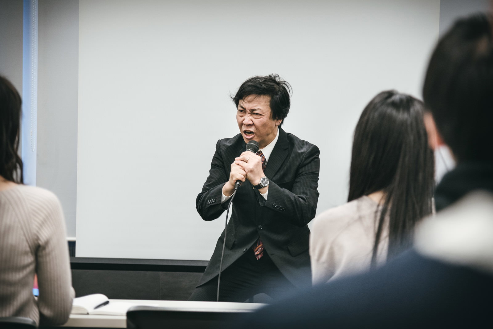 会議室で激昂する研修講師のスーツ姿の男性［モデル：のせさん］