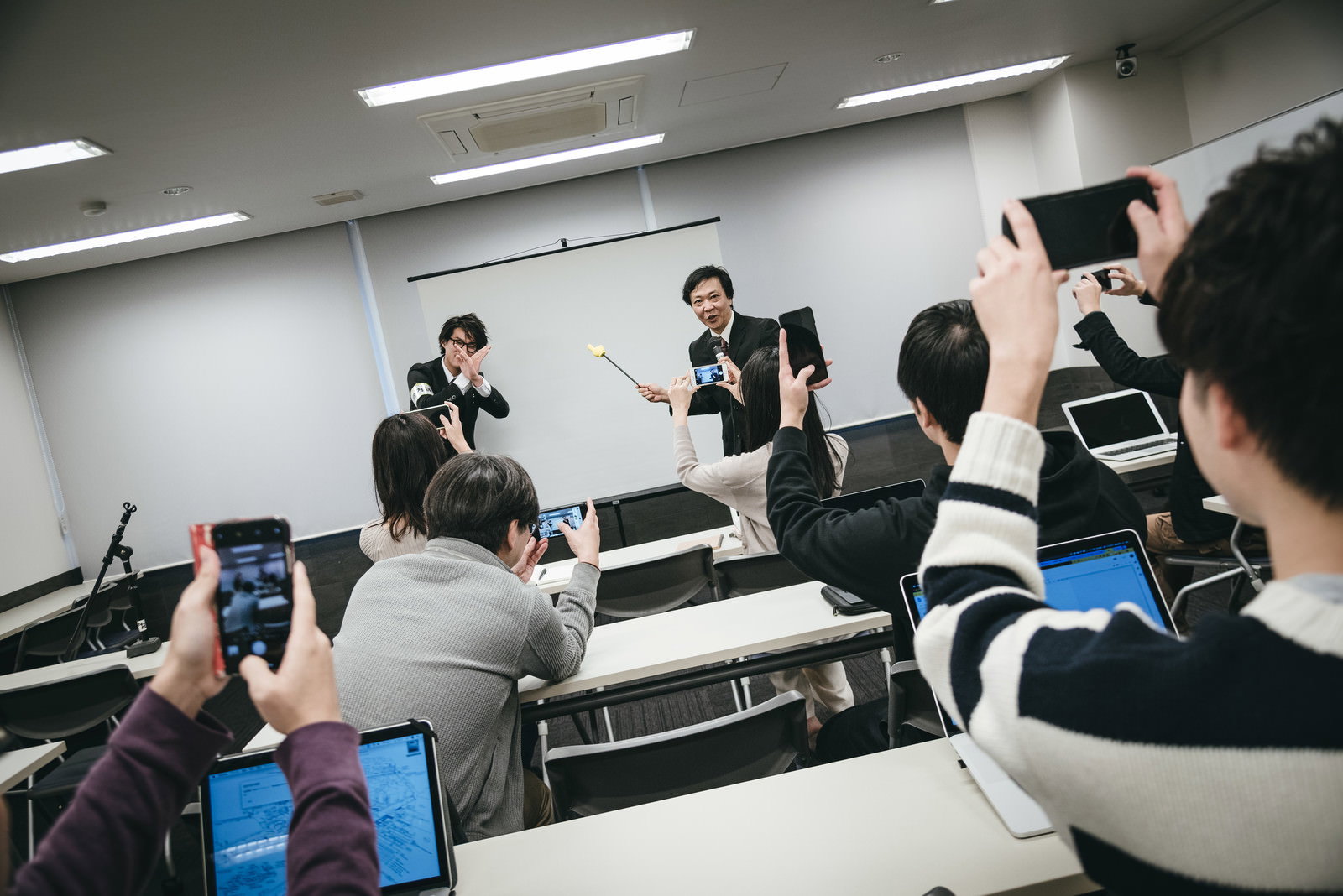 講義室で手でバツサインを作り撮影を制止する男性講師［モデル：村田裕章 のせさん］