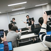 撮影禁止でお願いできますでしょうか？手でバツサインを作る男性講師の写真