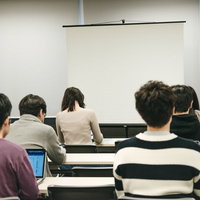 会議室のスクリーンを見つめるセミナー参加者の写真