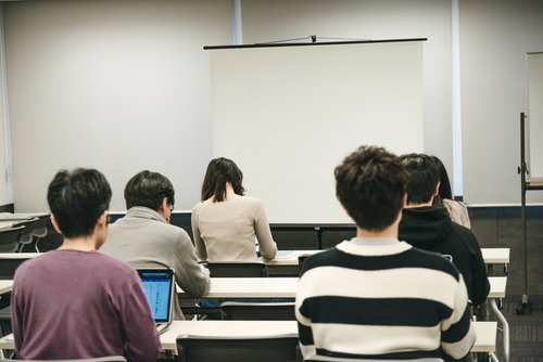 会議室のスクリーンを見つめるセミナー参加者
