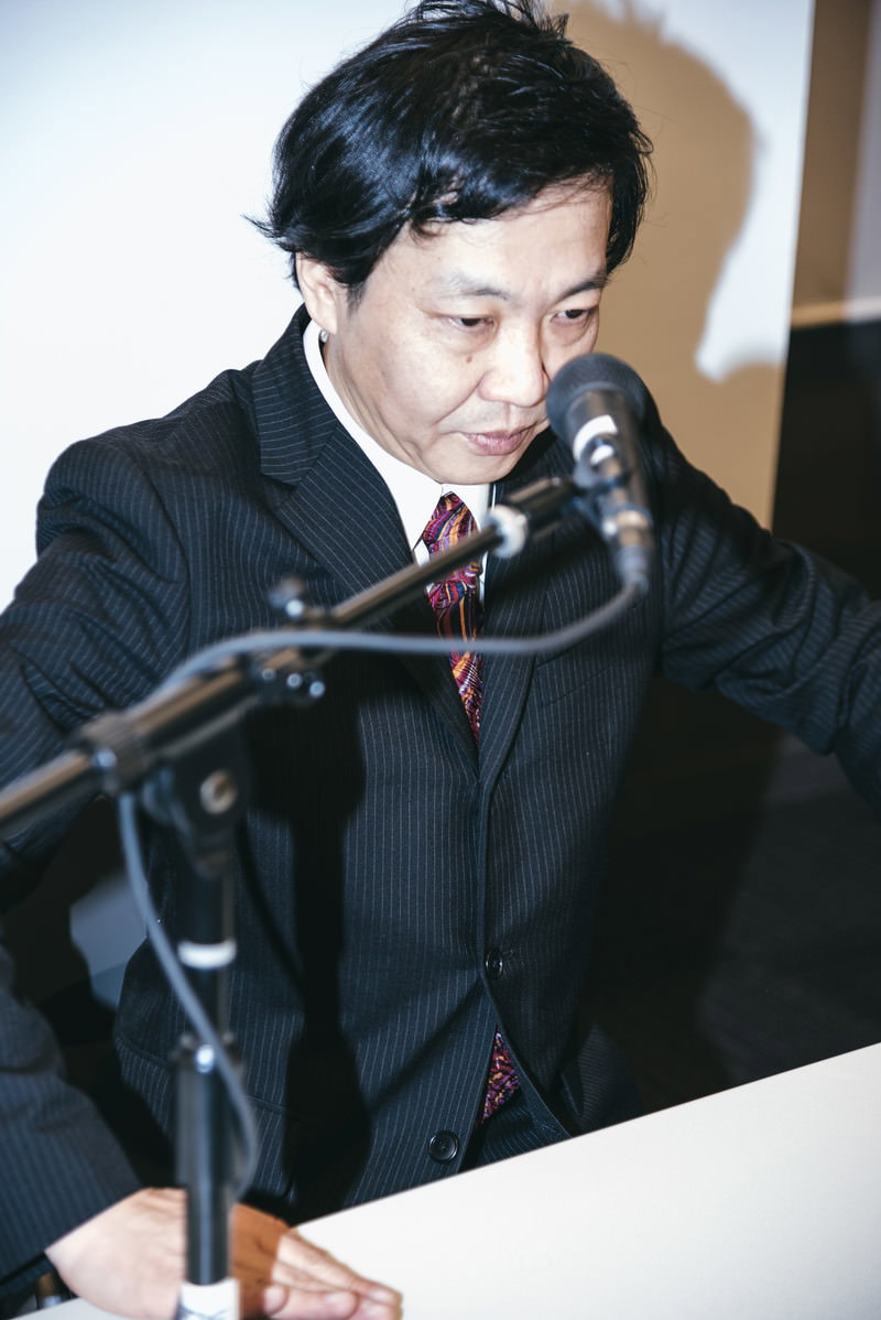 記者会見で深く頭を下げて謝罪する男性［モデル：のせさん］
