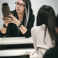 セミナー参加者に怪しい壺の魅力を話す男性の写真