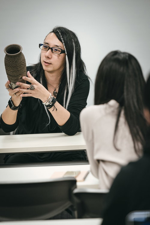 セミナー参加者に怪しい壺の魅力を話す男性