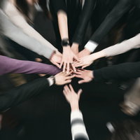 かるたの最後の一枚を前にチームで手を重ねて団結の写真