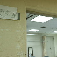 壁に貼られた手書きの更衣室の表示案内看板の写真