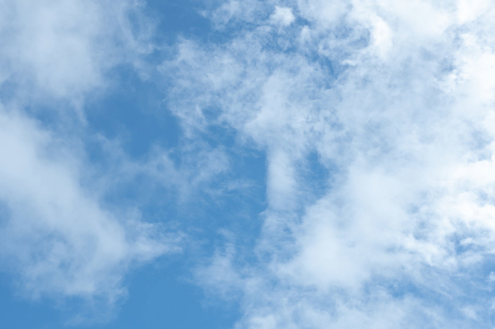 青空に薄い白雲が広がる晴れた空の風景
