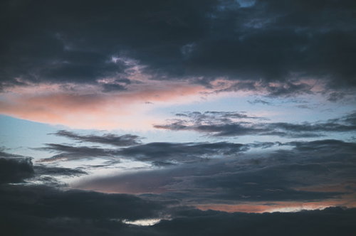 黒い雲から覗く青い空と夕焼けのグラデーション