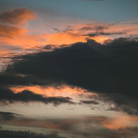 夕焼け空に浮かぶ黒い雲のグラデーション風景の写真