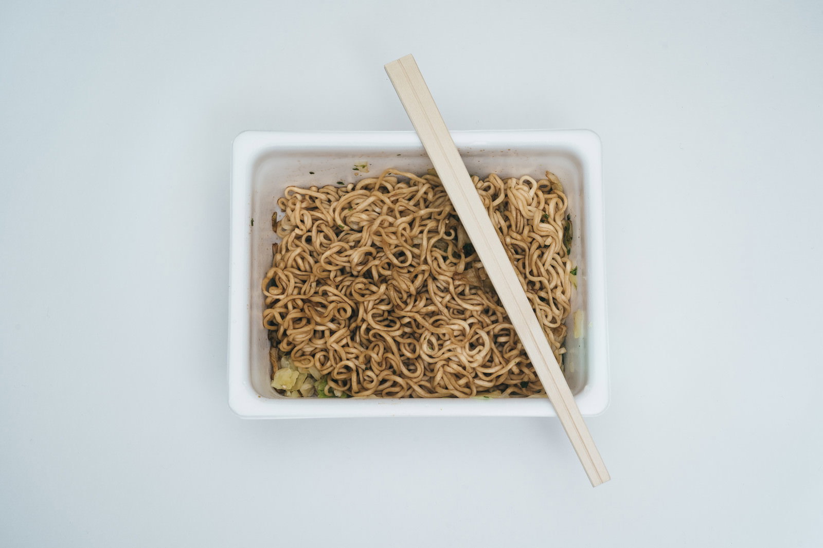 白い背景に置かれたペヤングソース焼きそばと木製の箸