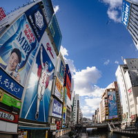 青い空と道頓堀遊歩道に立ち並ぶグリコの看板の写真