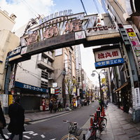 道頓堀の看板と路地に停められた自転車、グリコ看板の夜景の写真