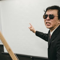 竹刀を持って怒鳴るスパルタ研修の講師によるパワハラ指導の写真