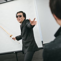 セミナーの鬼教官を見つめるスーツ姿の受講生の写真