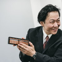 価格については勉強させていただきますとそろばんで交渉する営業男性の写真