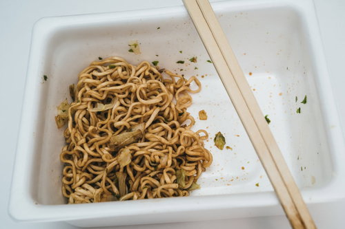 半分こなカップ焼きそば、箸で持ち上げた麺がほぐれた食べかけの様子