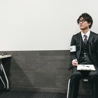 カウンターで人数を数える男性スタッフの業務風景の写真