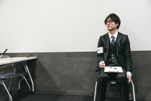 カウンターで人数を数える男性スタッフの業務風景