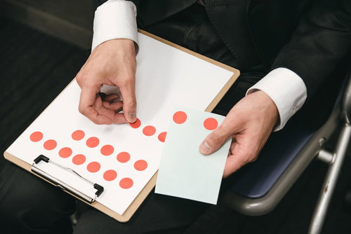 調査報告のシールを貼る手元と結果記録