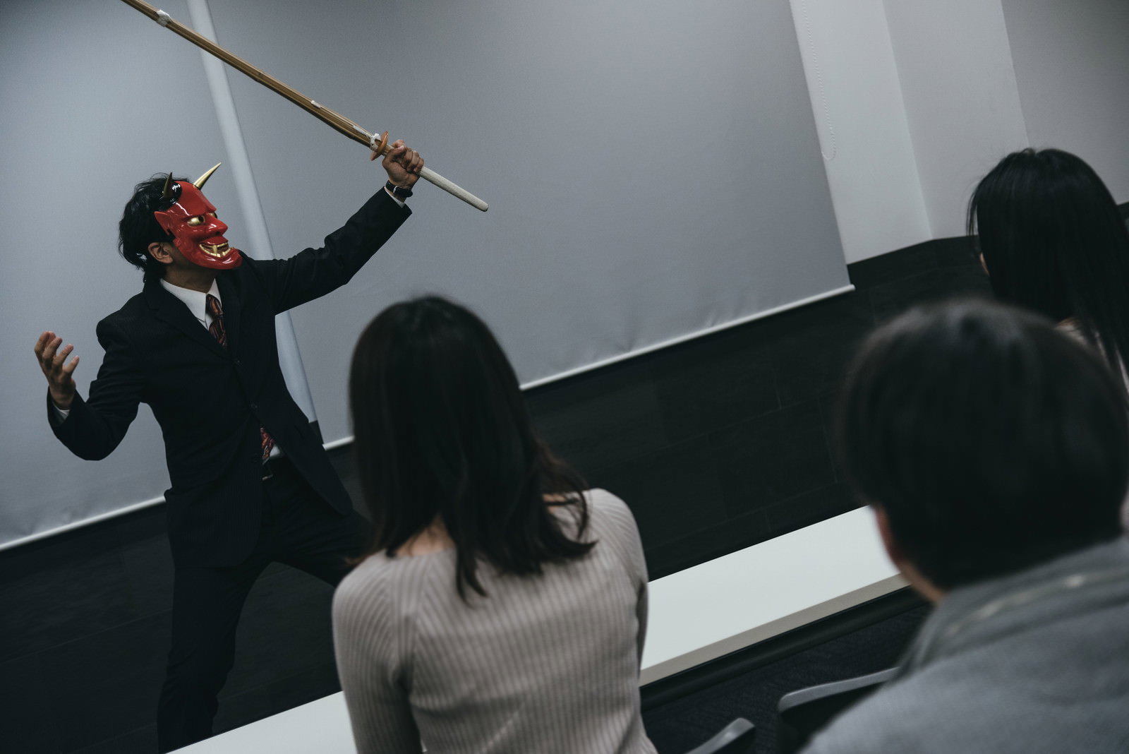 竹刀を持ったスーツの男性が研修を行っている様子［モデル：のせさん］