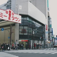 大阪十三本一商店街、トミータウンの赤い看板が目立つアーケード入り口の写真