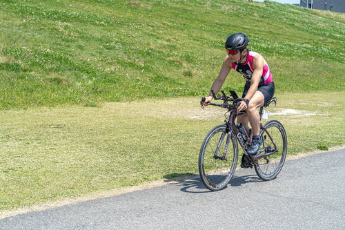 赤いヘルメットをかぶってロードバイクを運転するトライアスロンの選手