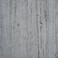 グレーのコンクリート壁に縦に流れる汚れと雨染みのテクスチャーの写真
