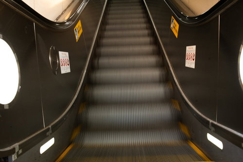 上昇する流れるエスカレーター - オフィスビルとショッピングセンターの移動施設