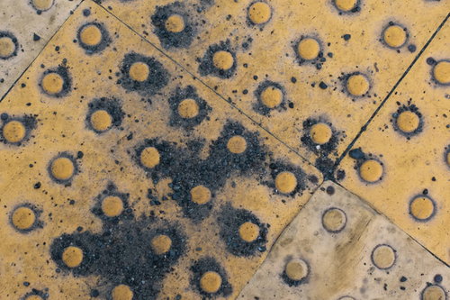 劣化した視覚障害者誘導ブロックの黄色いテクスチャー