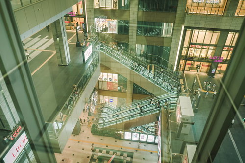 ガラス越しに見たショッピングモールのエスカレーター