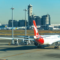 次のフライトでオーストラリアまで行く赤と白の旅客機の写真