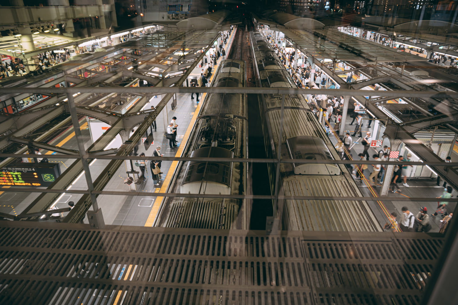 大阪駅のホームに到着する電車と多くの通勤客の俯瞰写真