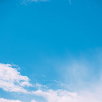 真っ青な快晴の空にぽっかり浮かぶ白い雲と積雲の写真