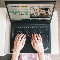 副収入について調べながらノートパソコンでタイピングする女性の写真