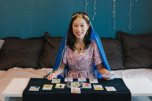 タロット占いをはじめた主婦がベッドでカードを広げる
