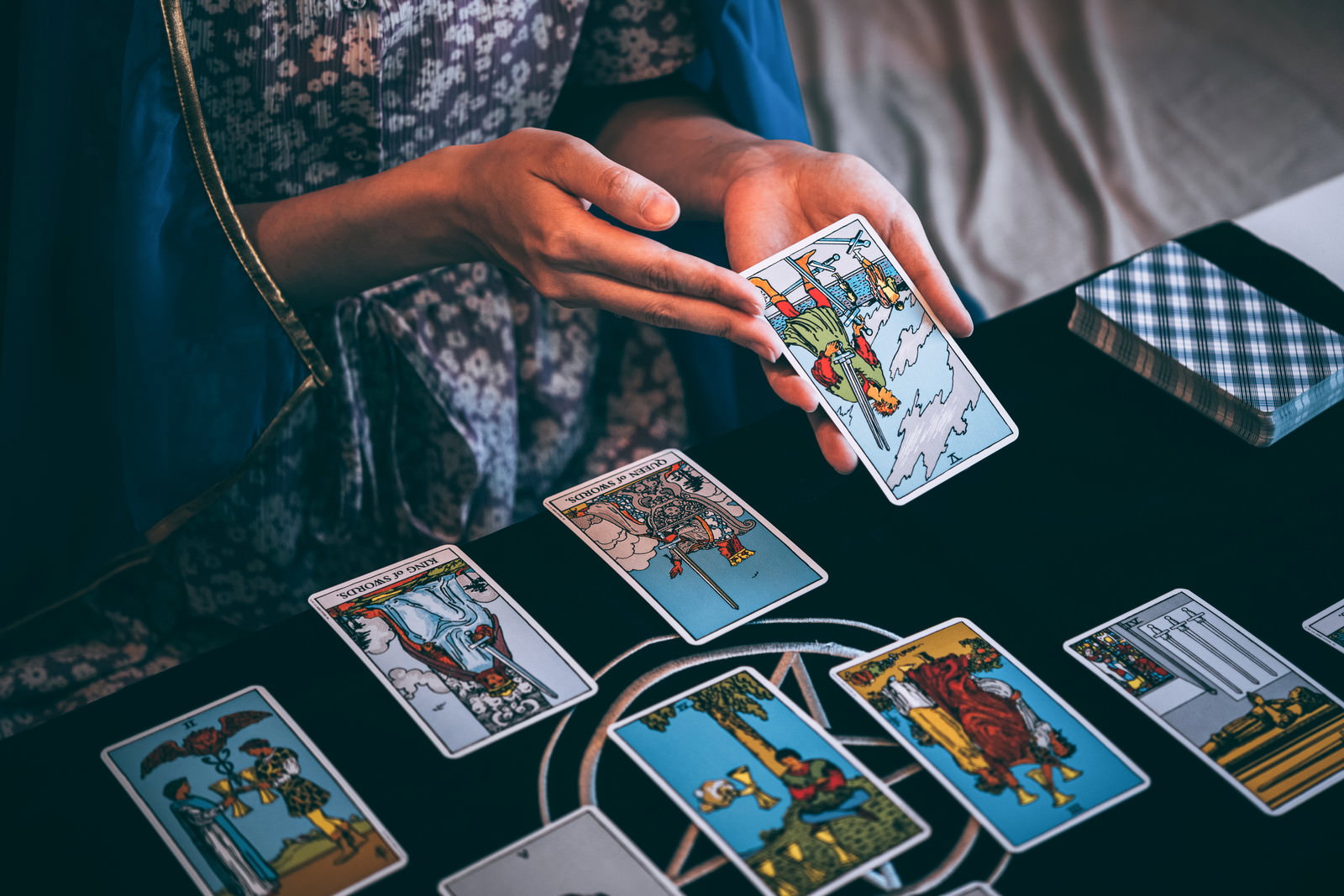 Woman holding tarot cards on a black table