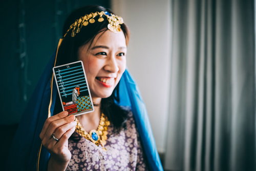 笑顔でソードの9を選ぶ占い師のタロット占い