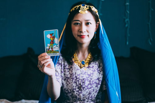 ソードの王子（正位置）のタロットカードを選ぶ女性占い師