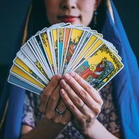 タロットカードを扇状に広げて見せる占い師の手元の写真